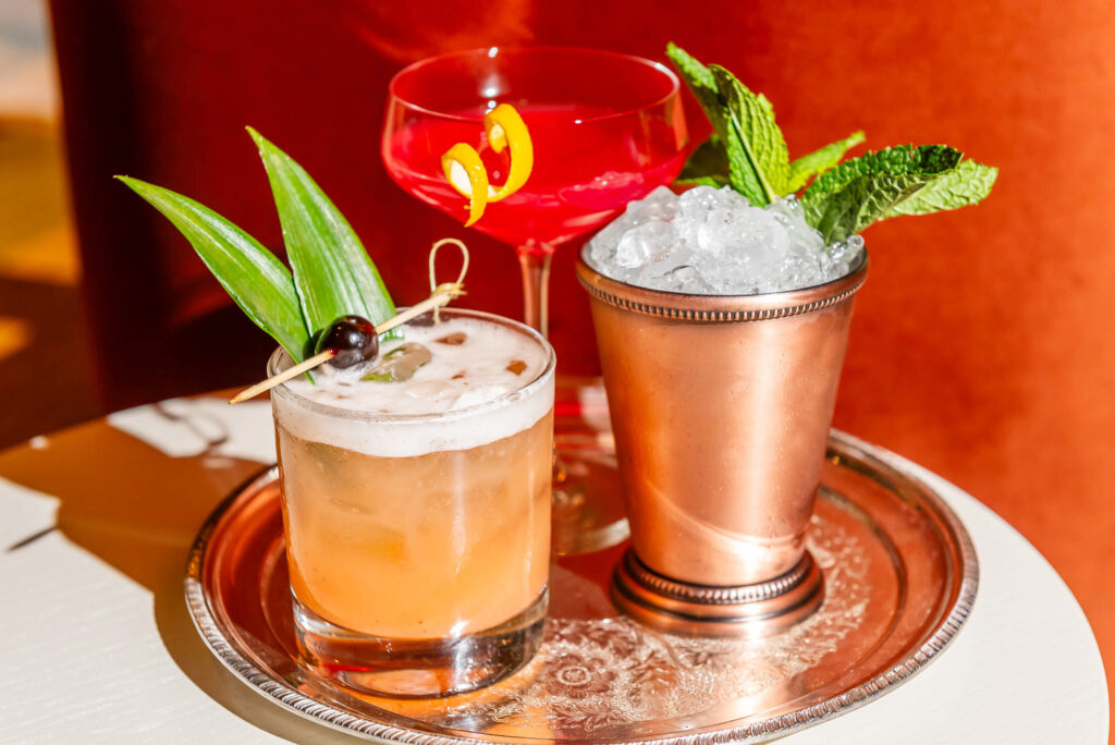 Three cocktails sitting on a silver tray at The Joneses restaurant in Toronto