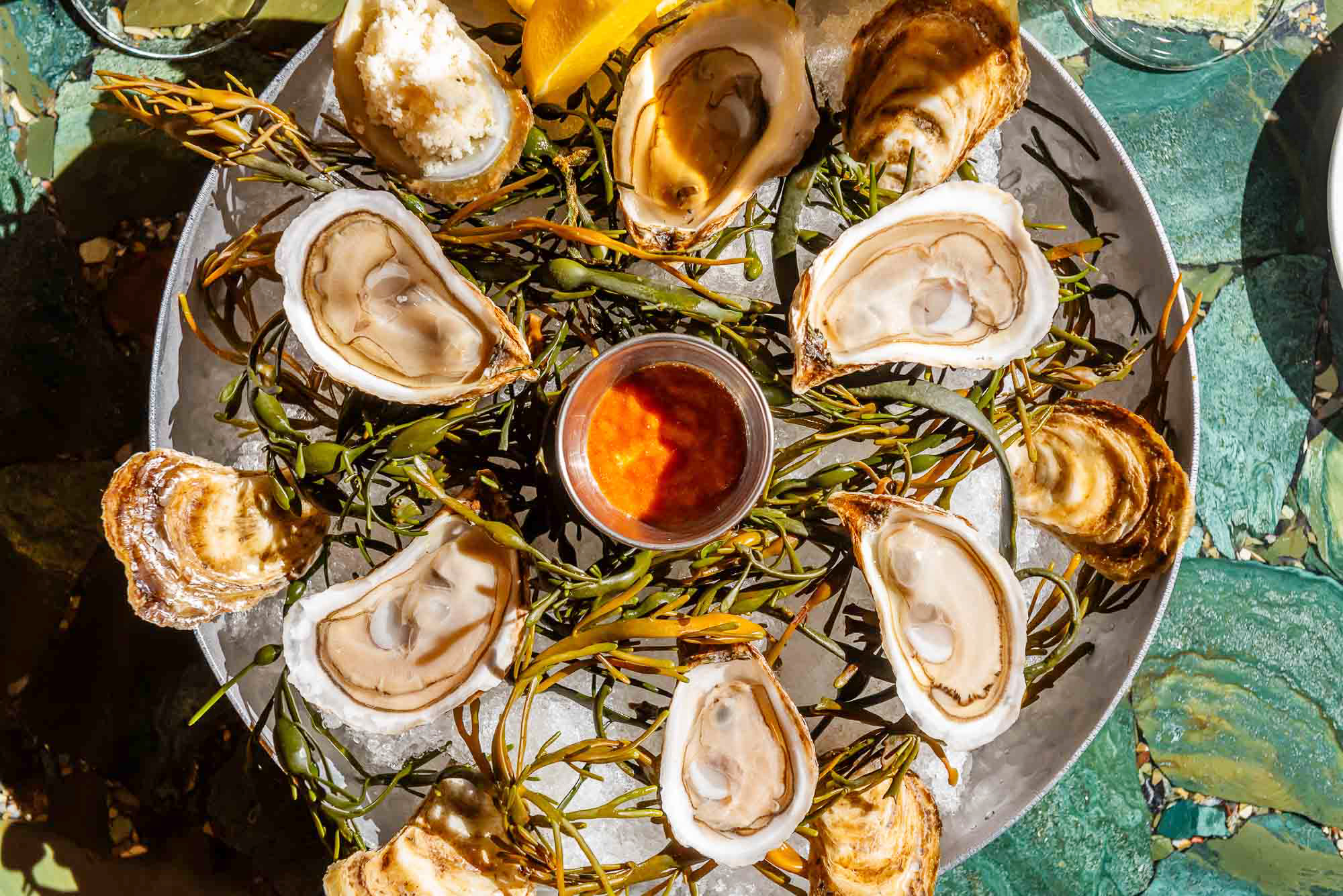 Overhead shot of a platted of oysters on a green table top at The Joneses
